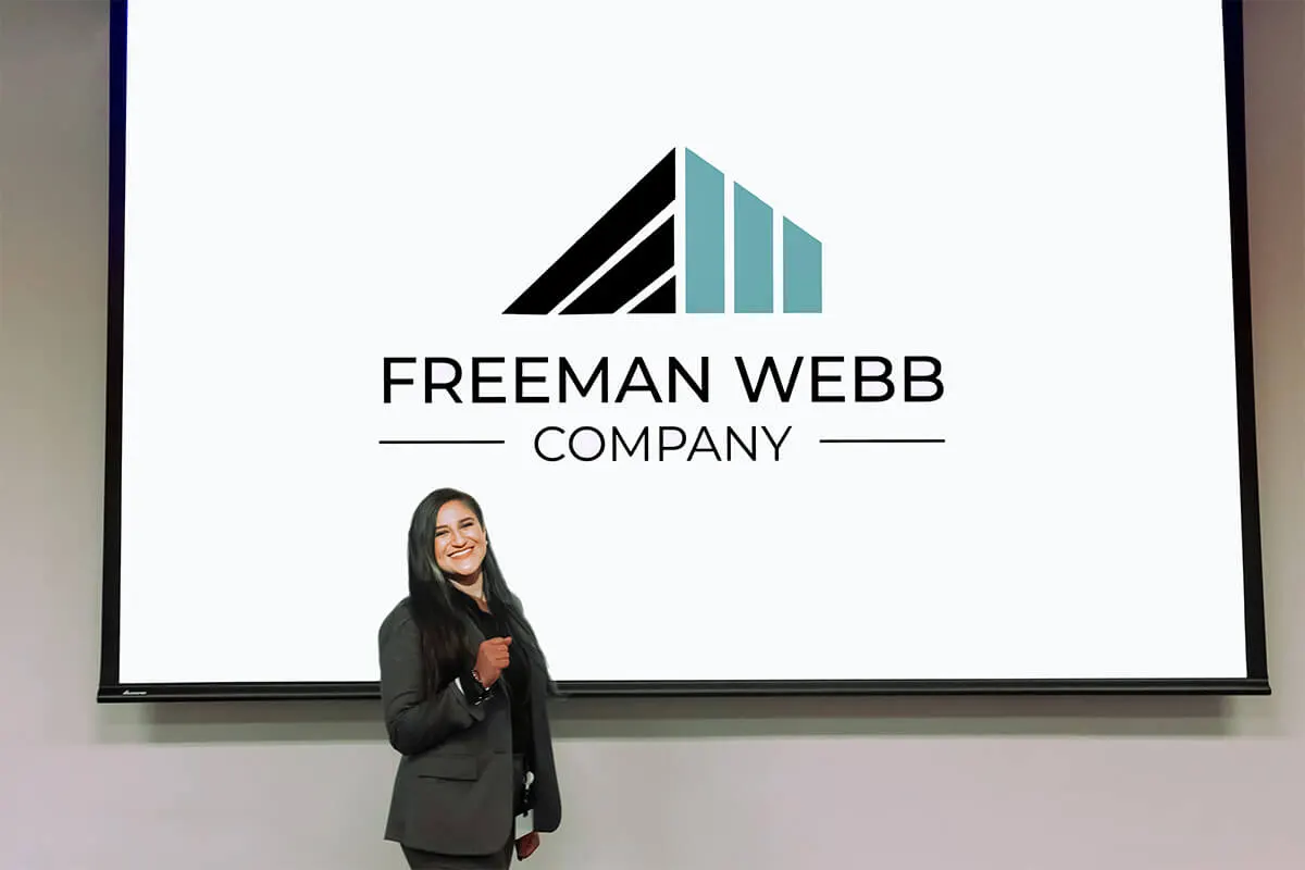 Employee in front of a Freeman Webb projector screen